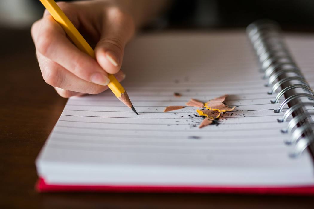 Kind schreibt mit Bleistift